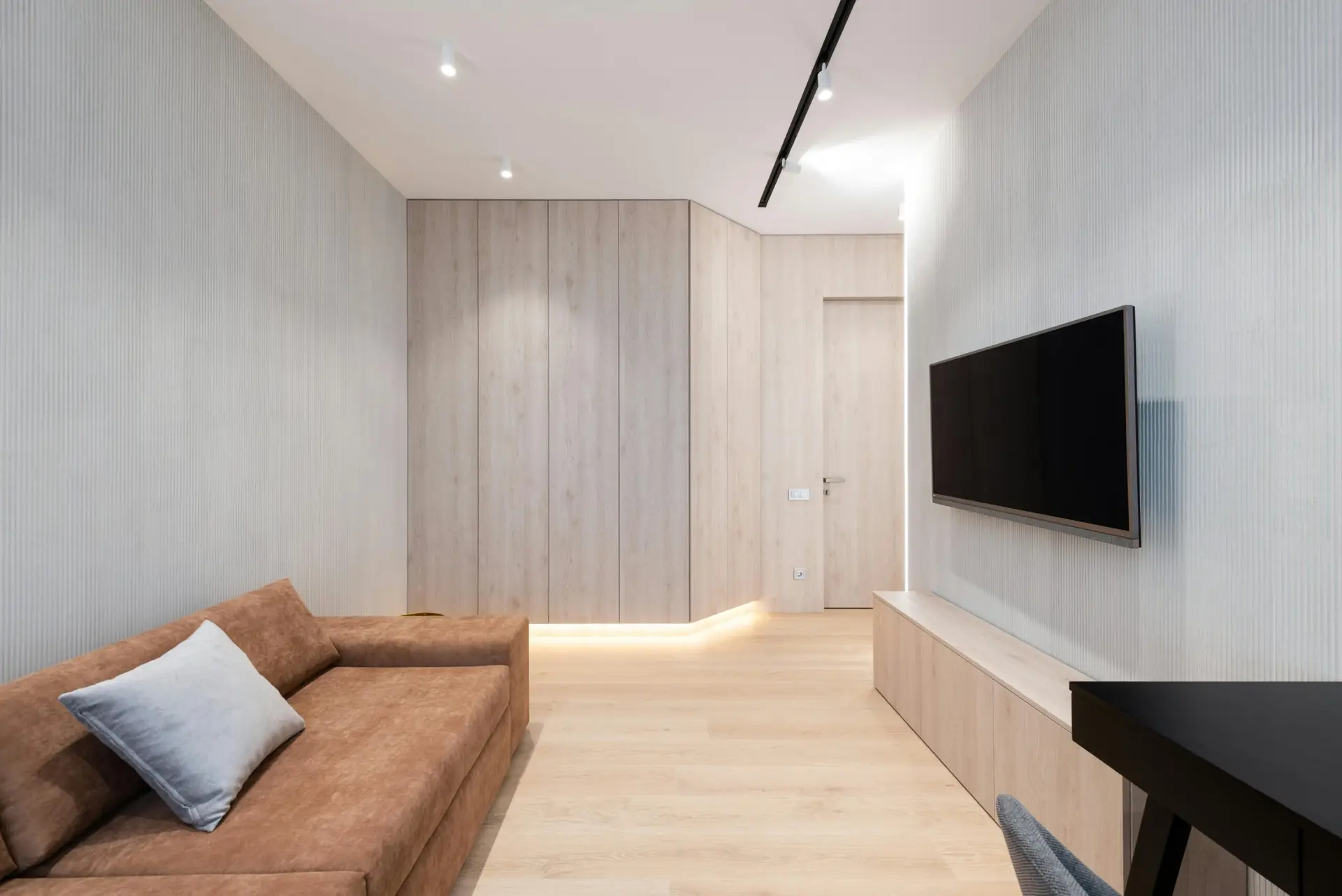 Sleek modern living room featuring a brown sofa and wall-mounted TV.